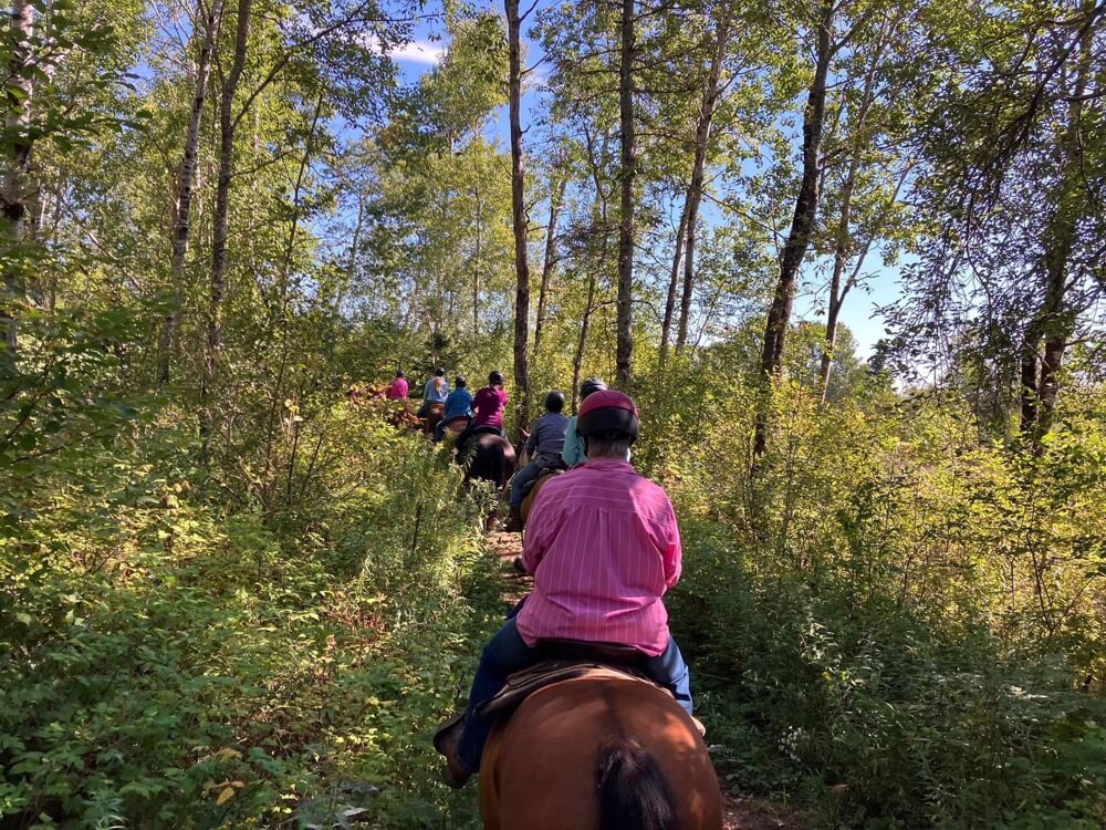 Horseback riders traveling along a wooded trail near Evangeline Trail Rides in Stanley Nova Scotia.